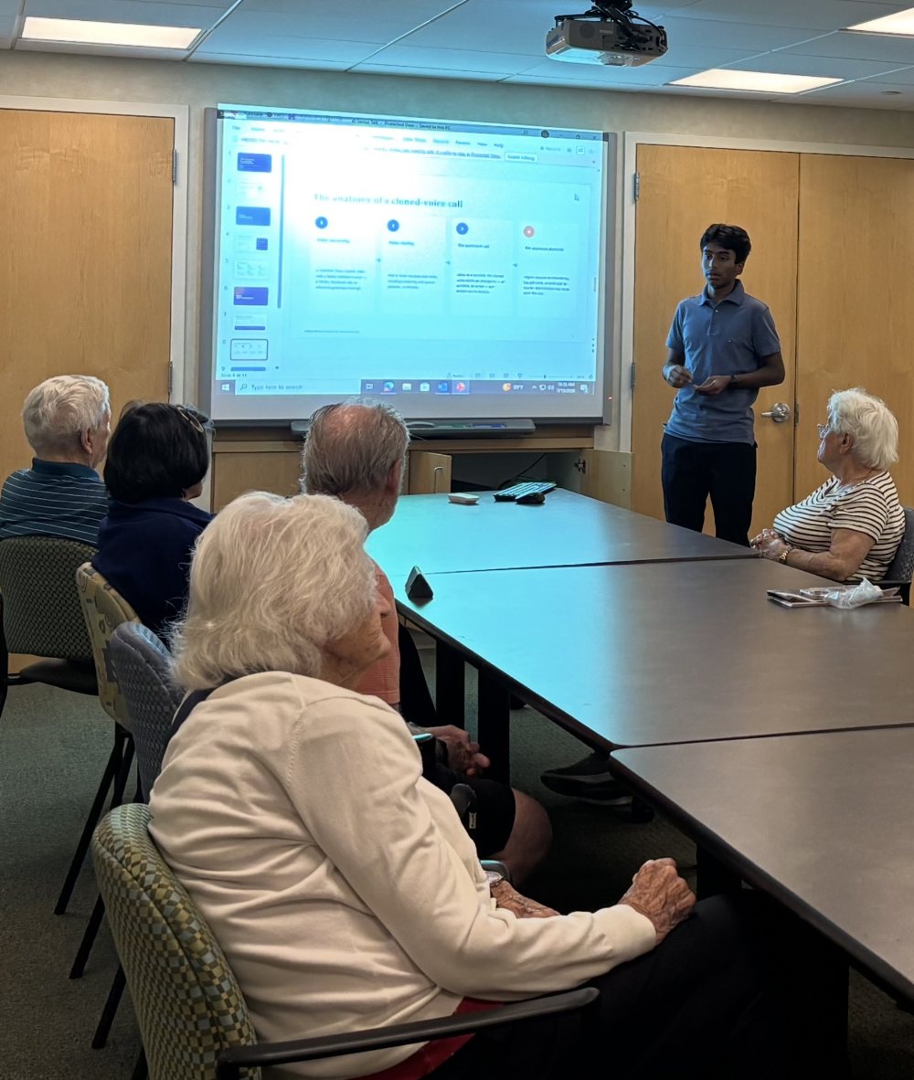 Presenting to residents at a senior living home, with a projected slide titled The anatomy of a cloned-voice call.